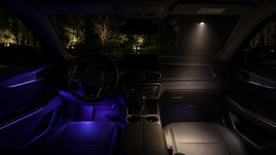 Soft purple footwell glow and a focused warm cabin light illustrate ambient and direct lighting inside a parked car at night