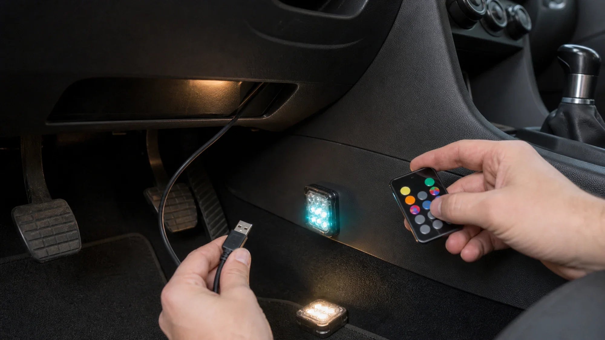 Checking a USB cable, remote, and compact ambient lights in a car footwell before mounting