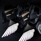 Angel wing puddle lights creating a dramatic door-open welcome effect beside the car at night.