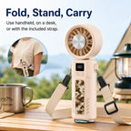 Foldable handheld fan used as a desktop stand and carried with the included strap