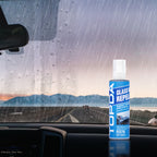 Car glass water repellent bottle inside a rainy windshield view for wet-weather windshield care.