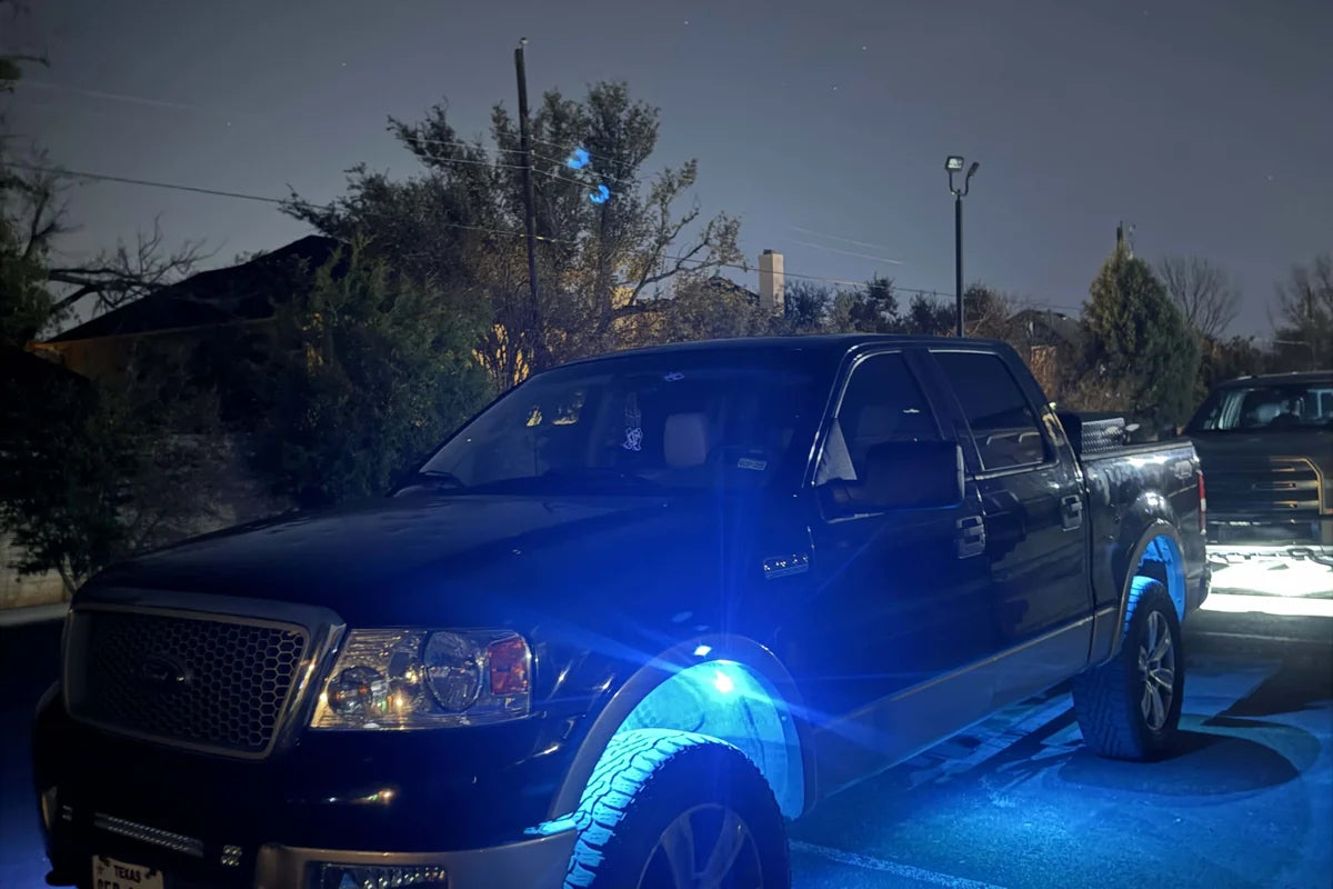 Blue rechargeable LED accent lights around a truck wheel area for a brighter custom nighttime look.