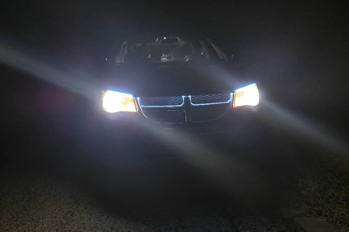 Ice blue LED hood light tracing the grille line between illuminated headlights at night.