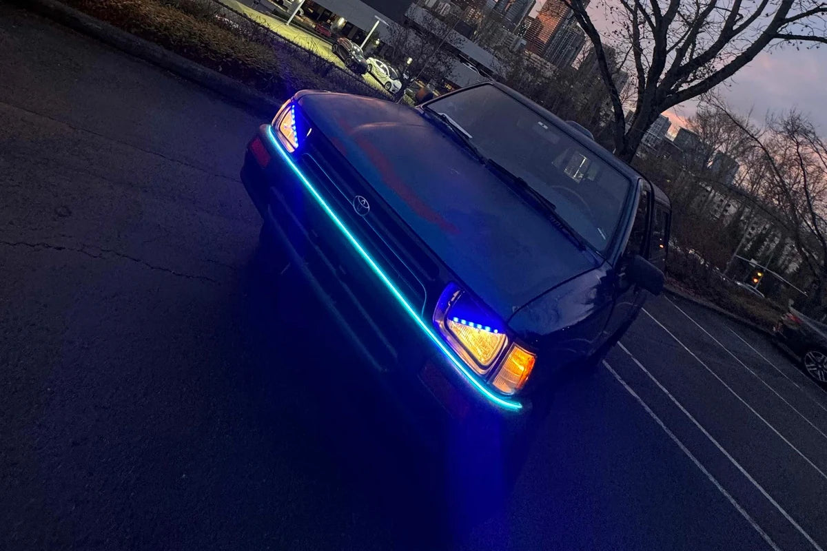 Ice blue hood LED accent strip lighting the front edge of a truck at sunset.