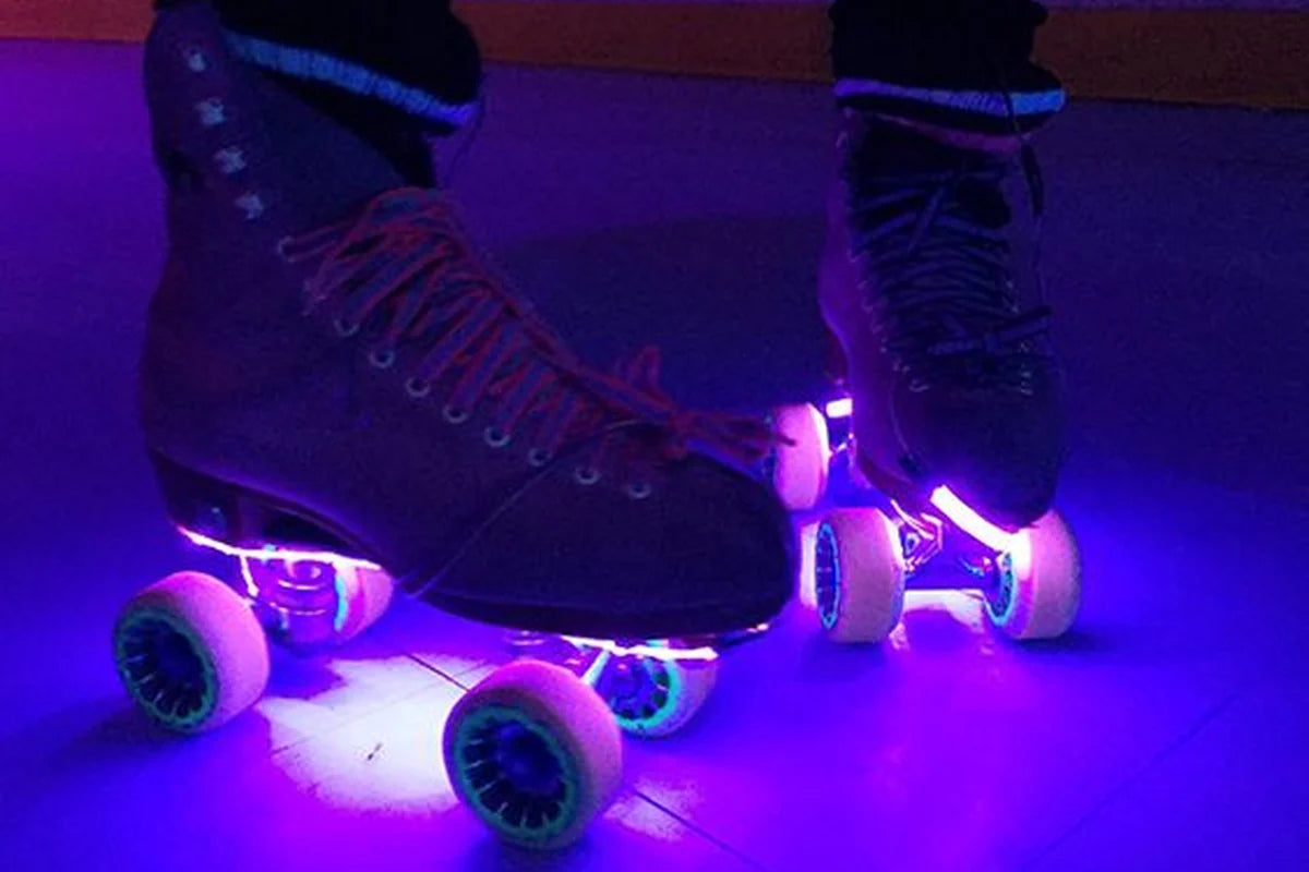 Purple LED accent lights under roller skates for a playful glow on indoor wheels.